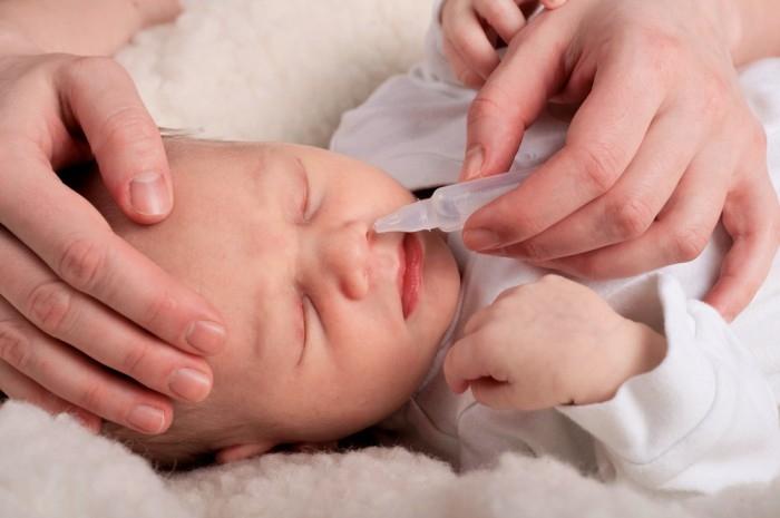Sử dụng dung dịch nước muối sinh lí để vệ sinh mắt, mũi cho bé.