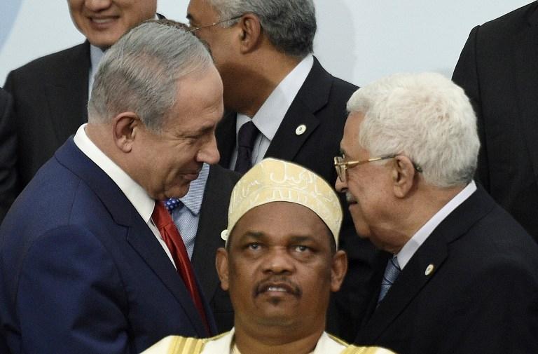 Thủ tướng Israel Benjamin Netanyahu (trái) bắt tay và nói chuyện với Tổng thống Palestine Mahmud Abbas sau lưng Tổng thống Comoros Ikililou Dhoinine.