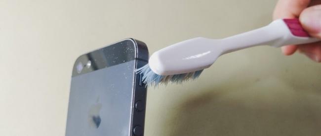 Loại bỏ bụi bẩn xung quanh các nút ấn trên smartphone bằng một chiếc bàn chải