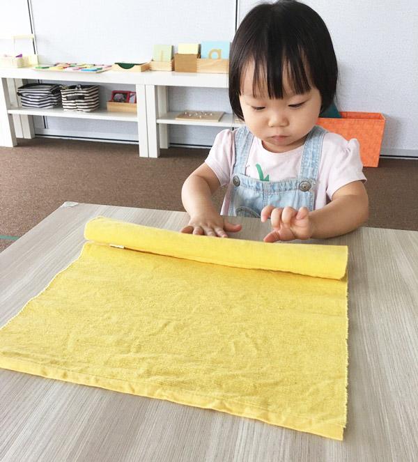 Trải và cuộn thảm giúp cho bé rèn luyện các đầu ngón tay linh hoạt.